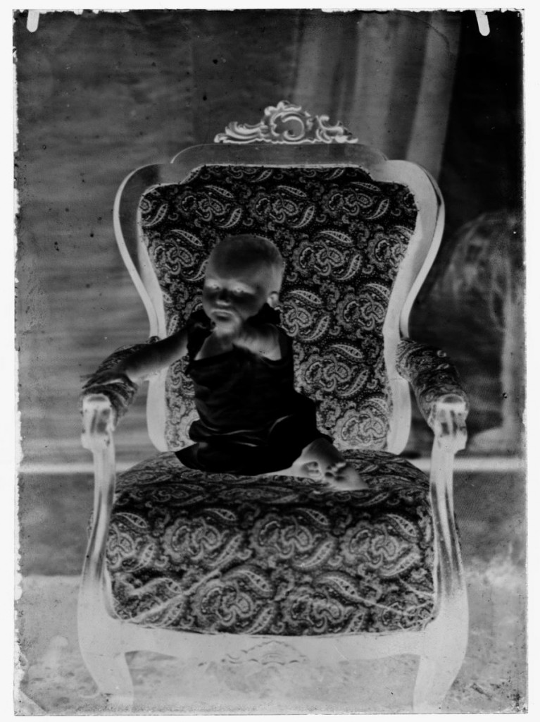 				Otrok v naslanjaču<br>Metlika, okoli leta 1910, negativ na stekleni plošči, 16,4 x 11,9 cm<br>inv. št.: Ns 102			