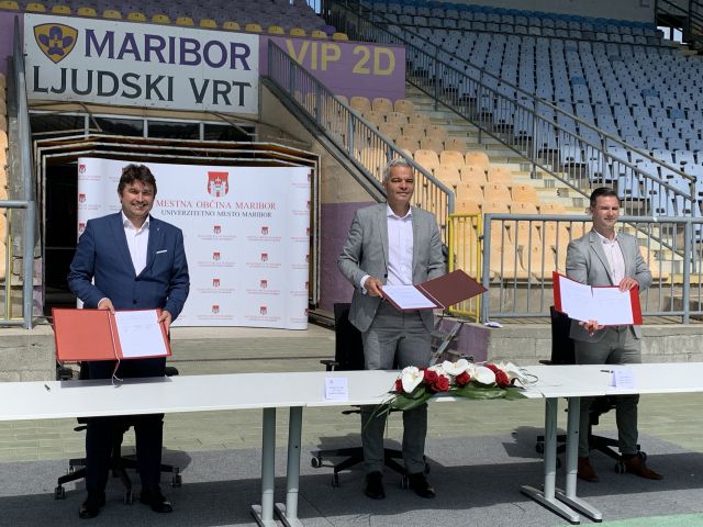 				Župan Arsenovič in Tadej Mežnar ob podpisu pogodbe z izvajalcem obnove zahodne tribune stadiona Ljudski vrt. 			